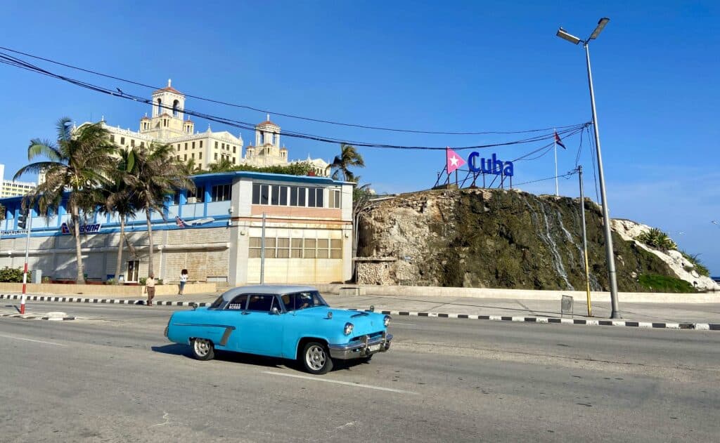 Куба пейзажна снимка с ретро кола и кубинскомзнаме